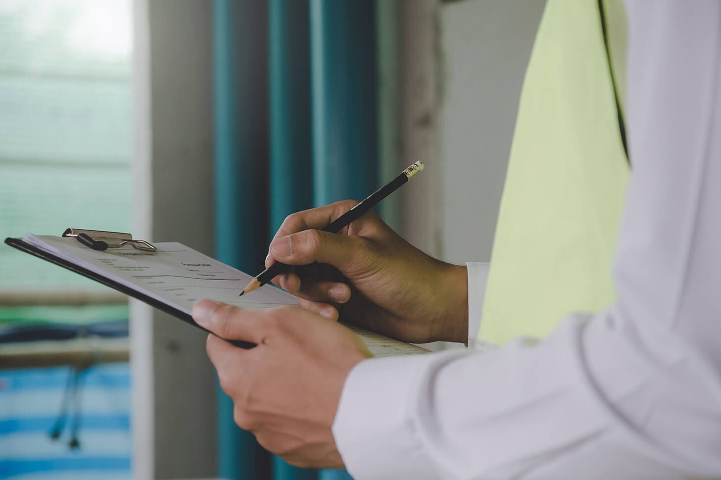 Person filling out a clipboard form.