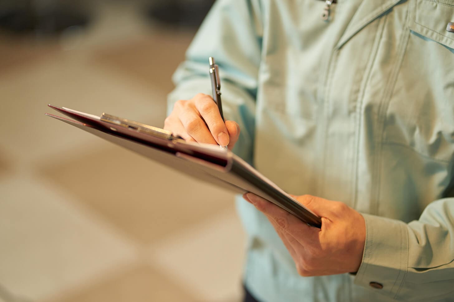 Person filling out clipboard paperwork.