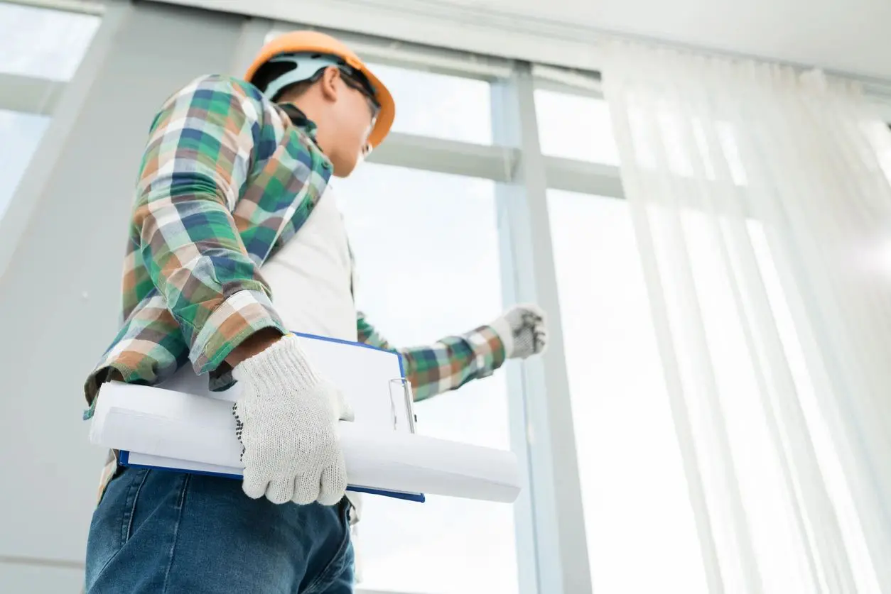 A man in plaid shirt holding construction paper.